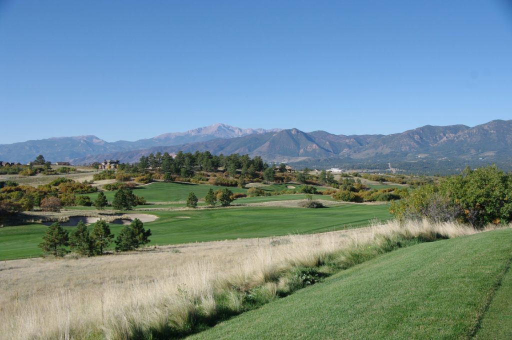 Golf course green with trees and mountains