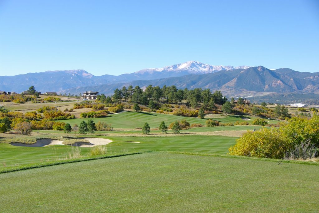 Golf course green with mountain range in distance