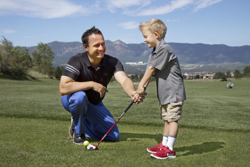 Garrett instructing junior golfer