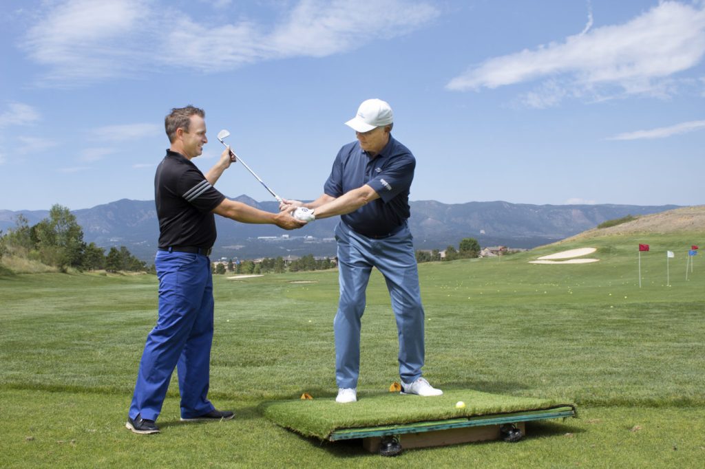 Garrett assisting golfer with swing