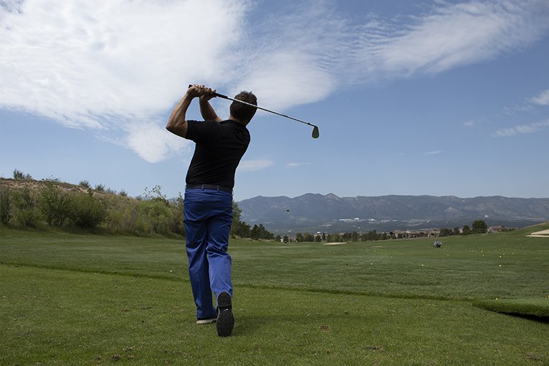 Golfer taking a swing on golf course
