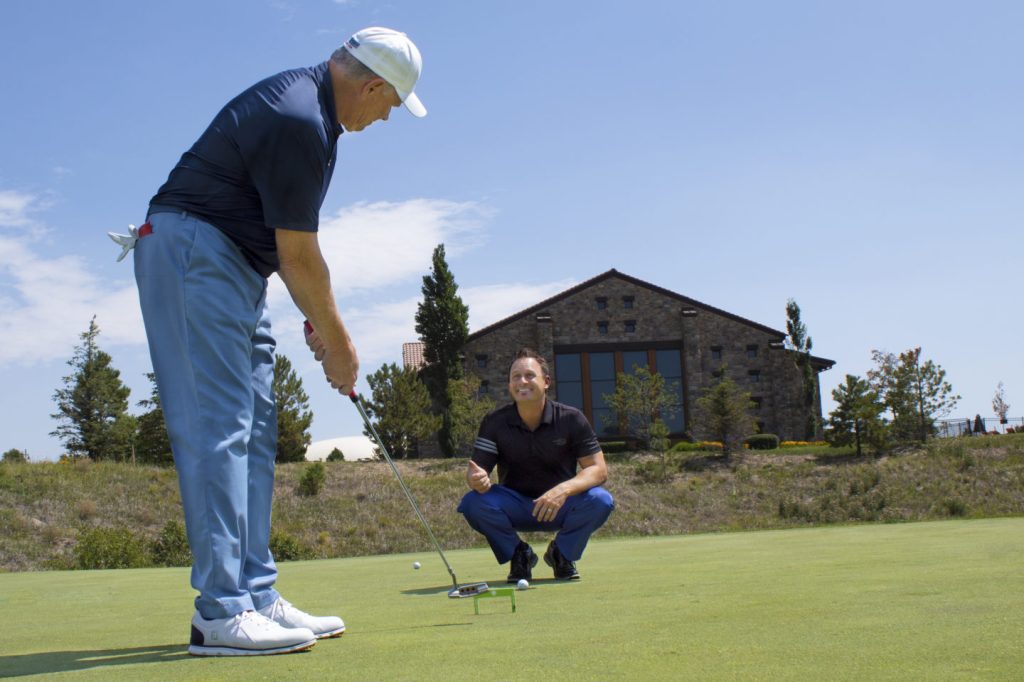Golfer receiving instruction from Garrett